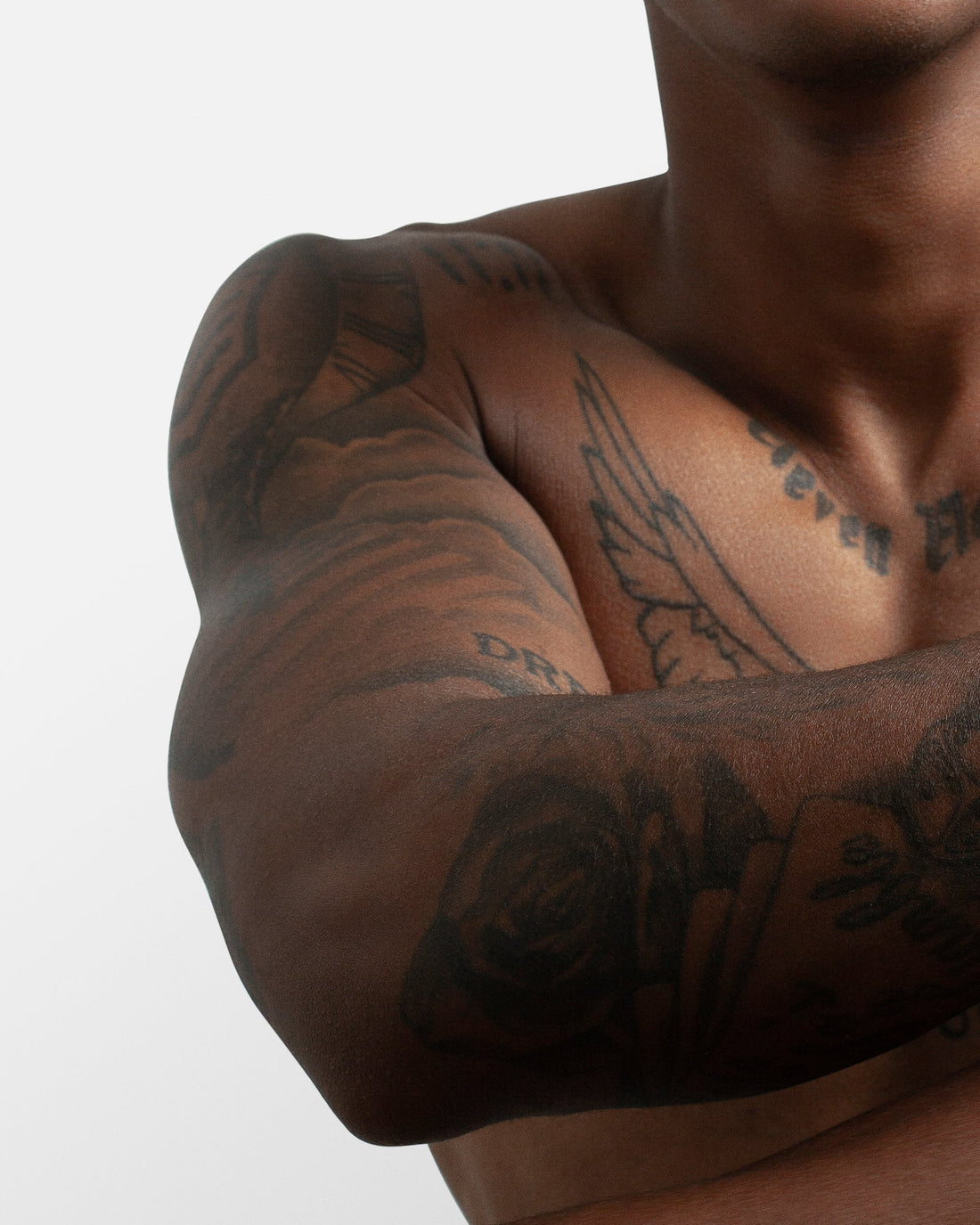 Close-up of a man's muscular arm with visible tattoos, flexing to showcase strength and muscle definition.  This image relates to the U-Pump Black Rhino performance enhancer and its potential to improve strength gains.